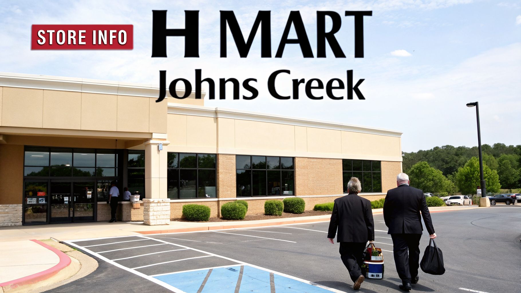 Two men in suits walk away from the H Mart Johns Creek grocery store with bags and a cooler.
