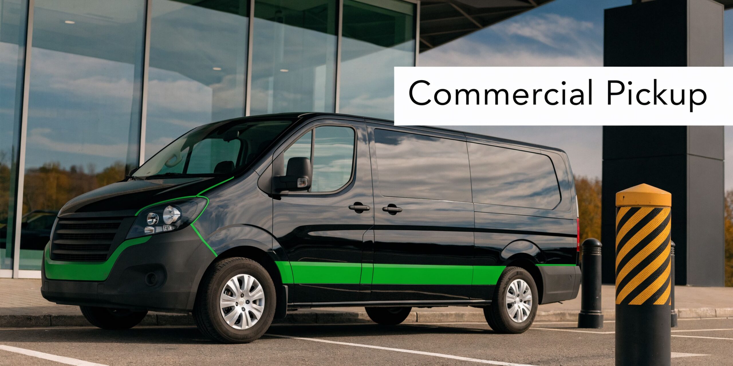 A black commercial delivery van with green stripes parked in front of a modern glass building